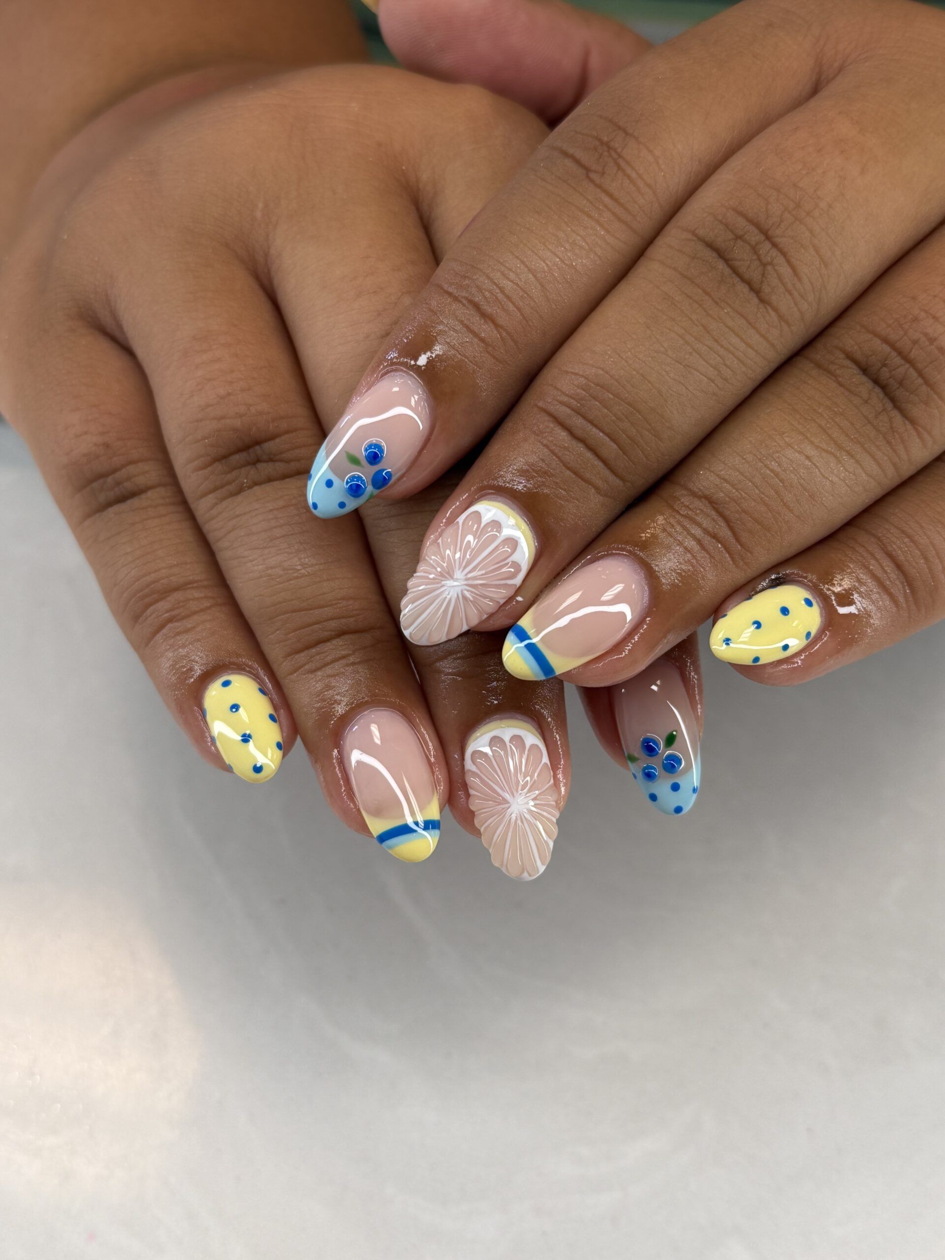 Nude almond nails with yellow and blue dot art