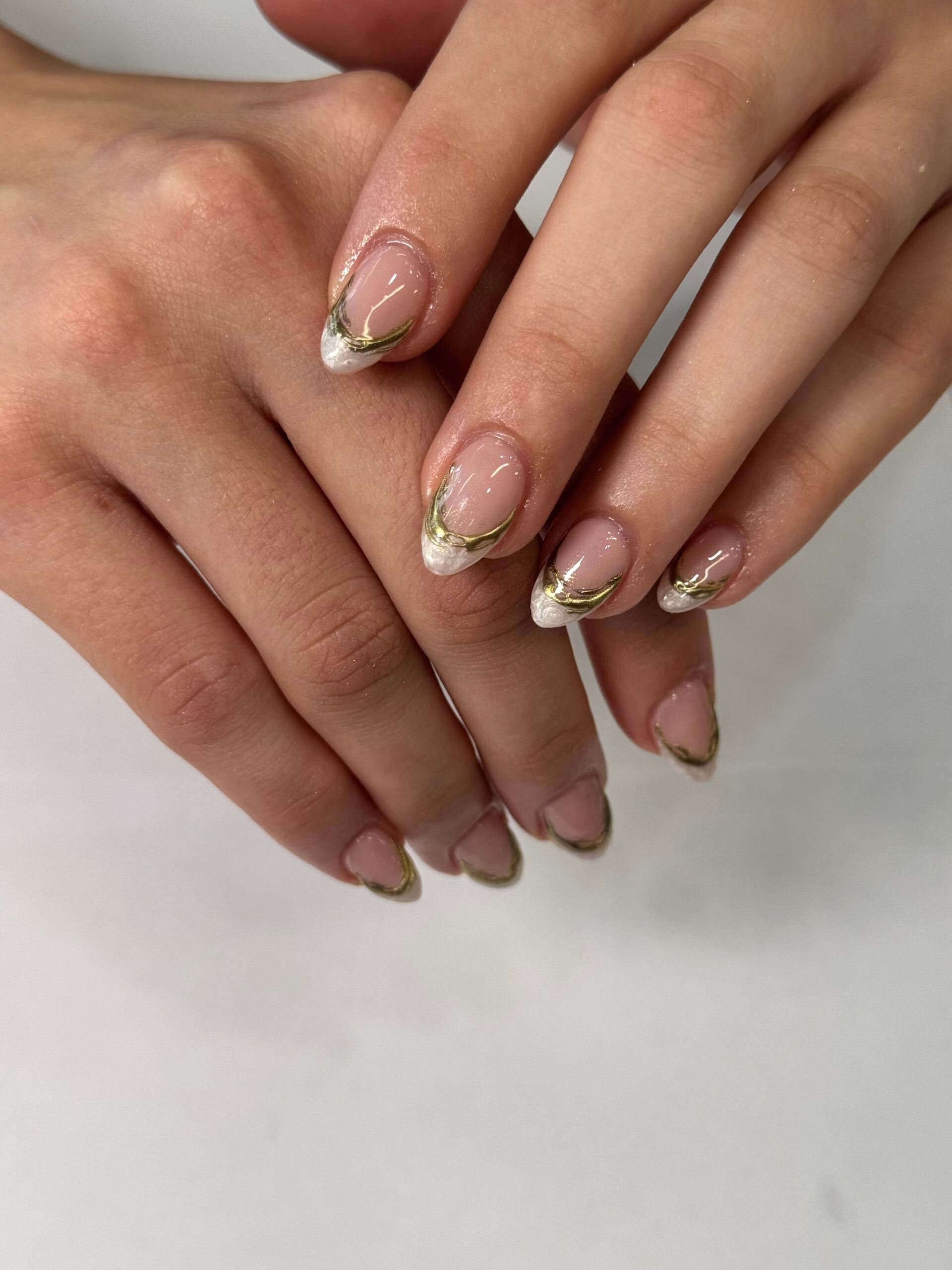 Sheer almond nails with gold French outline