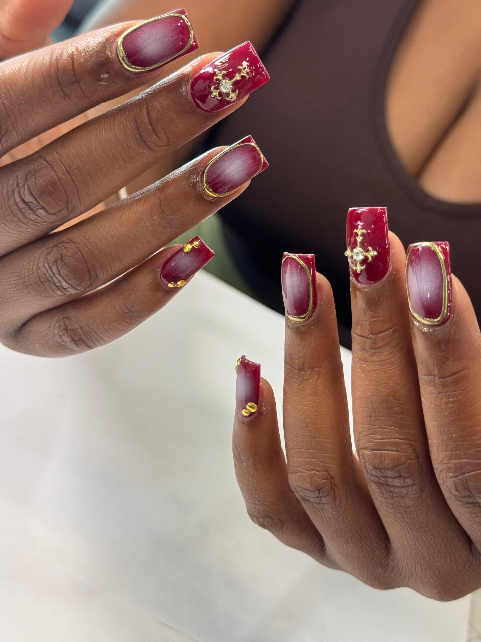 Burgundy aura nails with gold charms